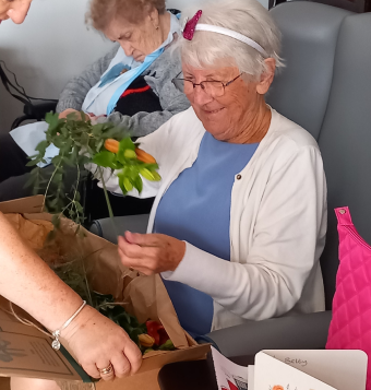 One of our residents sat in a chair participating in a flower arranging activity